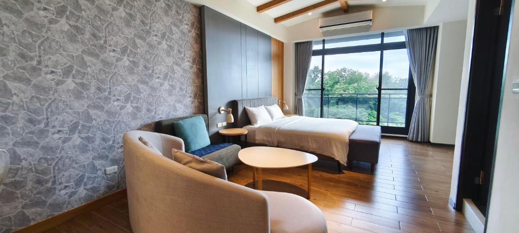 a hotel room with two beds and a table and chairs at Meets Anping in Tainan