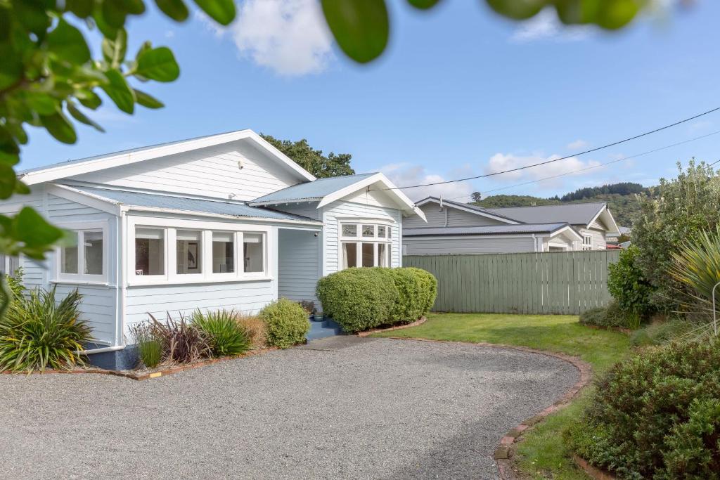 a white house with a driveway at Harrison House in Featherston