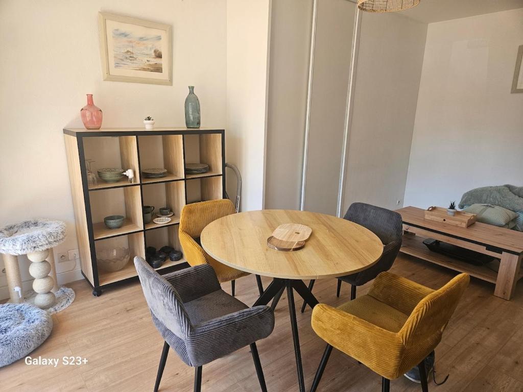 a living room with a wooden table and chairs at Studio 2 personnes in Cucq