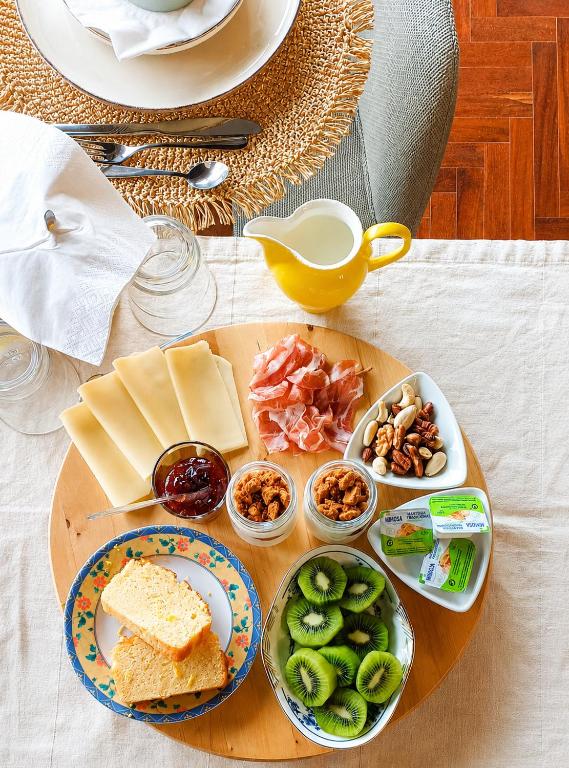 a tray of food with cheese and other foods on a table at SANTA RITA Guesthouse B&B in Vila Nova de Gaia