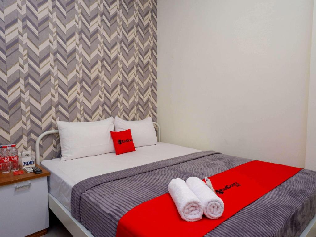 a bedroom with a bed with towels on it at RedDoorz Plus @ Karangploso in Karangploso