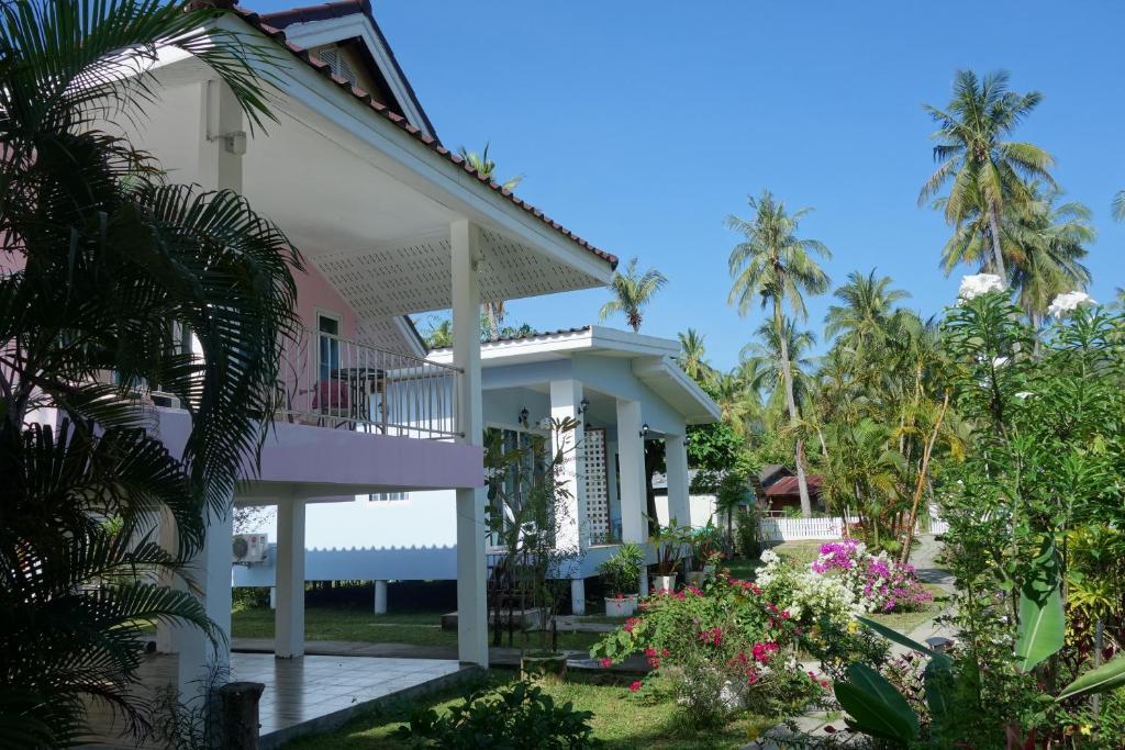 a house with a balcony and palm trees at Mook Ing Lay in Ko Mook