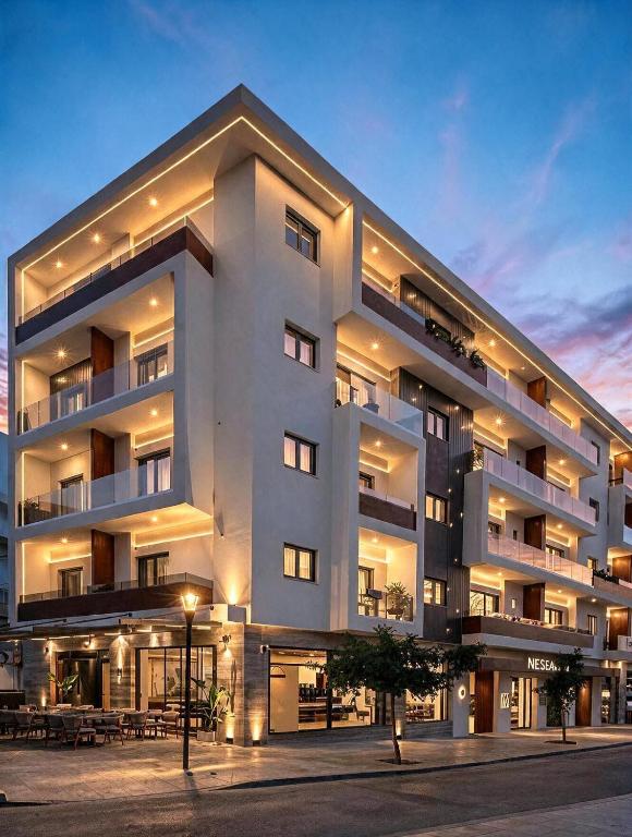 a large white building with tables in front of it at Nesean Plaza Hotel in Heraklio