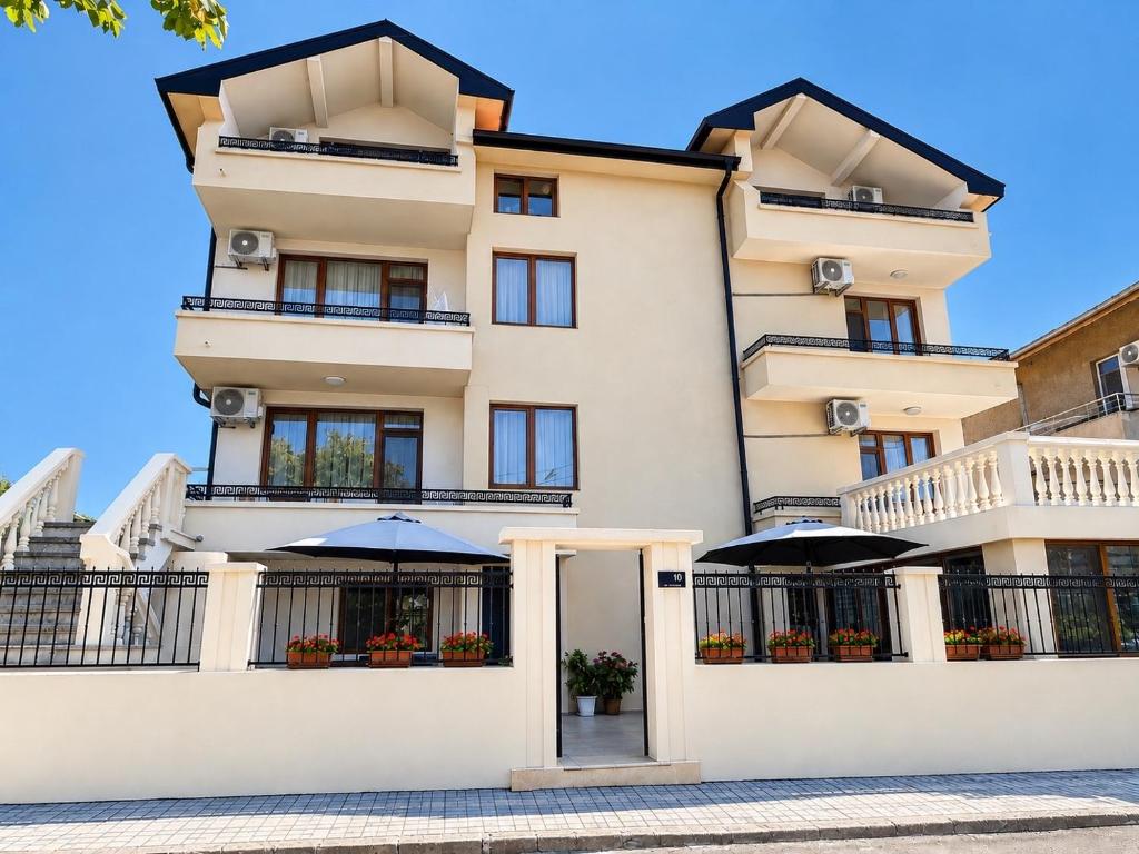 an apartment building with umbrellas in front of it at Guestrooms Zoya in Chernomorets