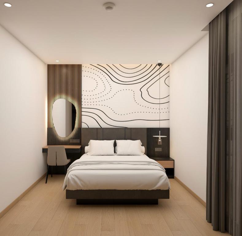 a bedroom with a bed and a painting on the wall at Dragon Hotel in Rạch Giá