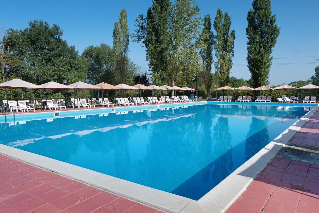 a large swimming pool with chairs and umbrellas at Camping La Chiocciola a Capannole in Capannole