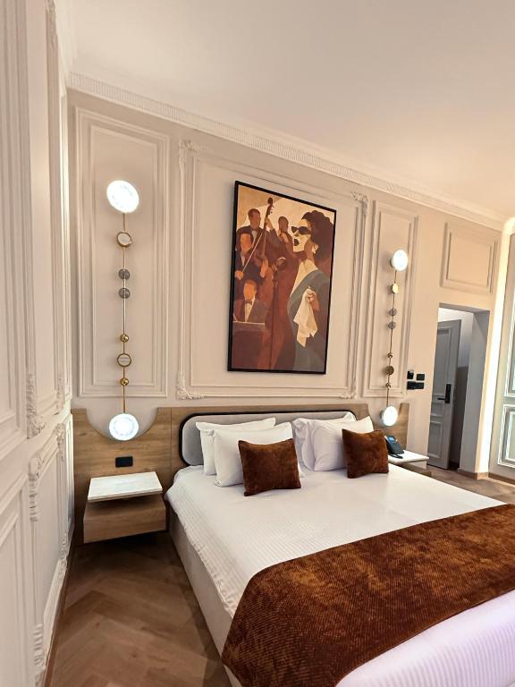 a bedroom with a large bed with a painting on the wall at AJIRA Zamalek Hotel in Cairo