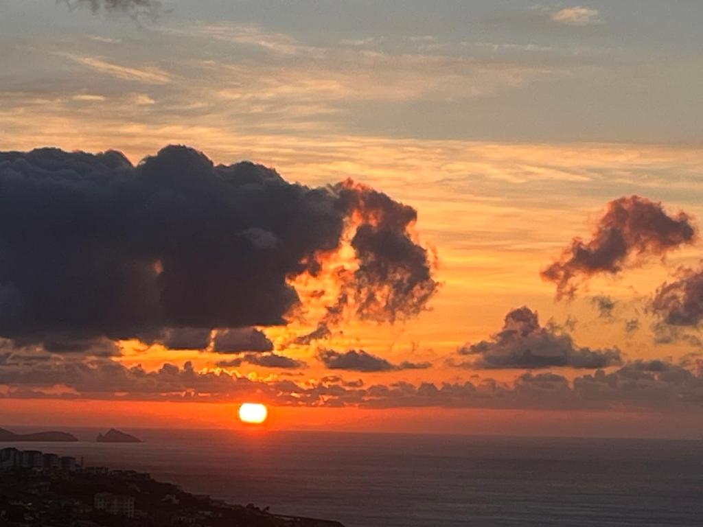 a sunset over the ocean with the sun setting at Apartamento Fénix Garajau in Caniço