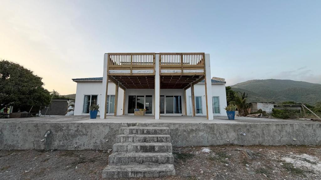 a large white house with a roof at YAI Wellness Oasis in Yallahs