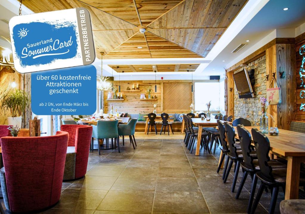 a restaurant with wooden ceilings and tables and chairs at LODGE HOTEL Winterberg in Winterberg
