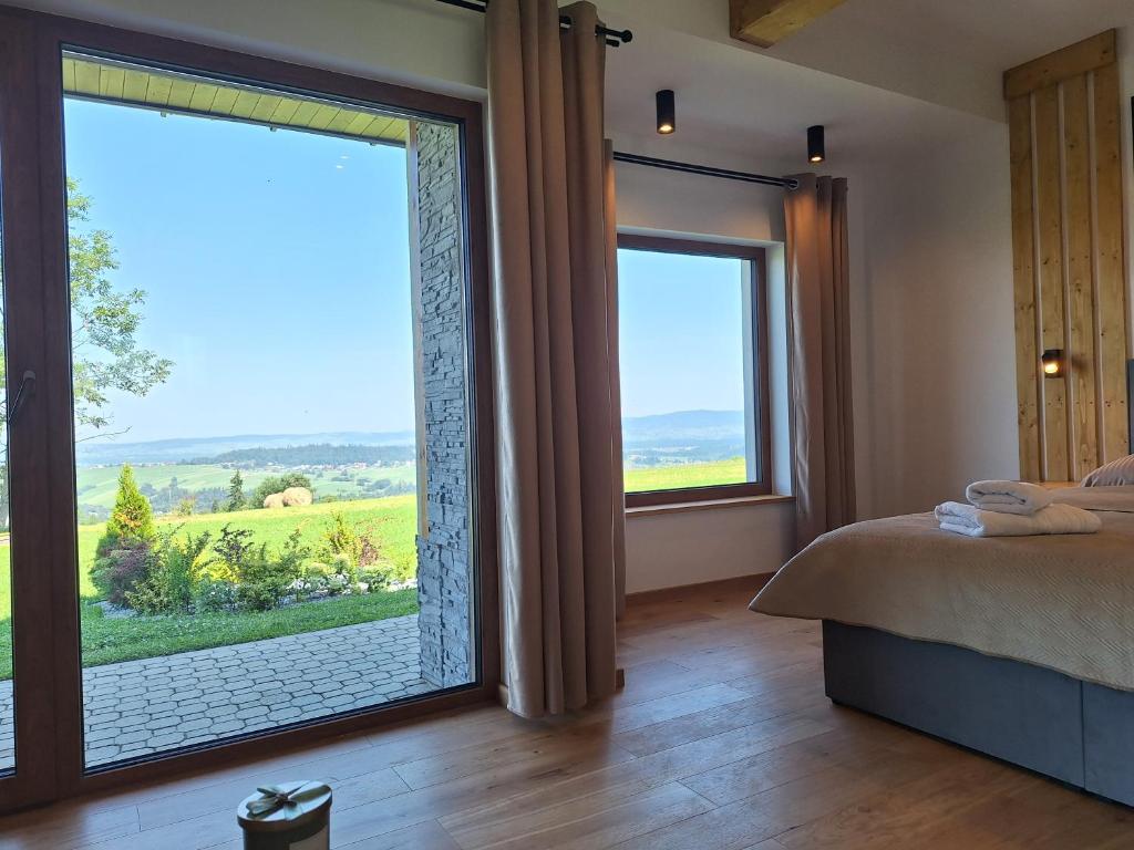 a bedroom with a large window with a view at Apartament Polana No 24 in Bańska Wyżna