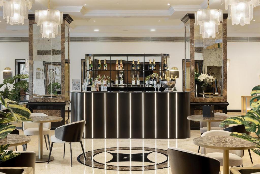 A glossy lobby bar is framed by mirrors, chandeliers and marble-effect columns.