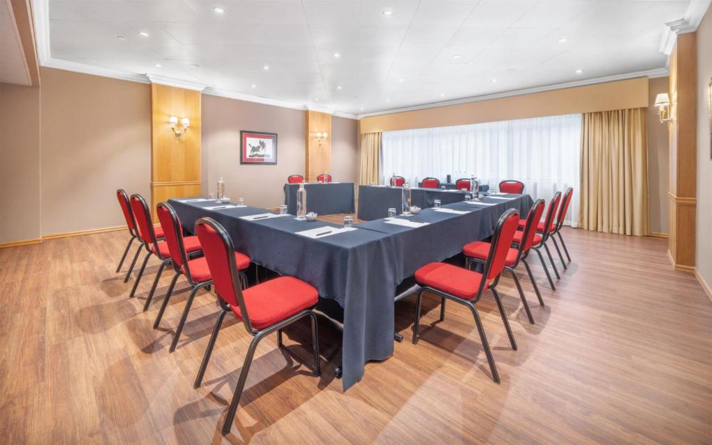 A spacious boardroom-style meeting room with a U-shaped table arrangement.