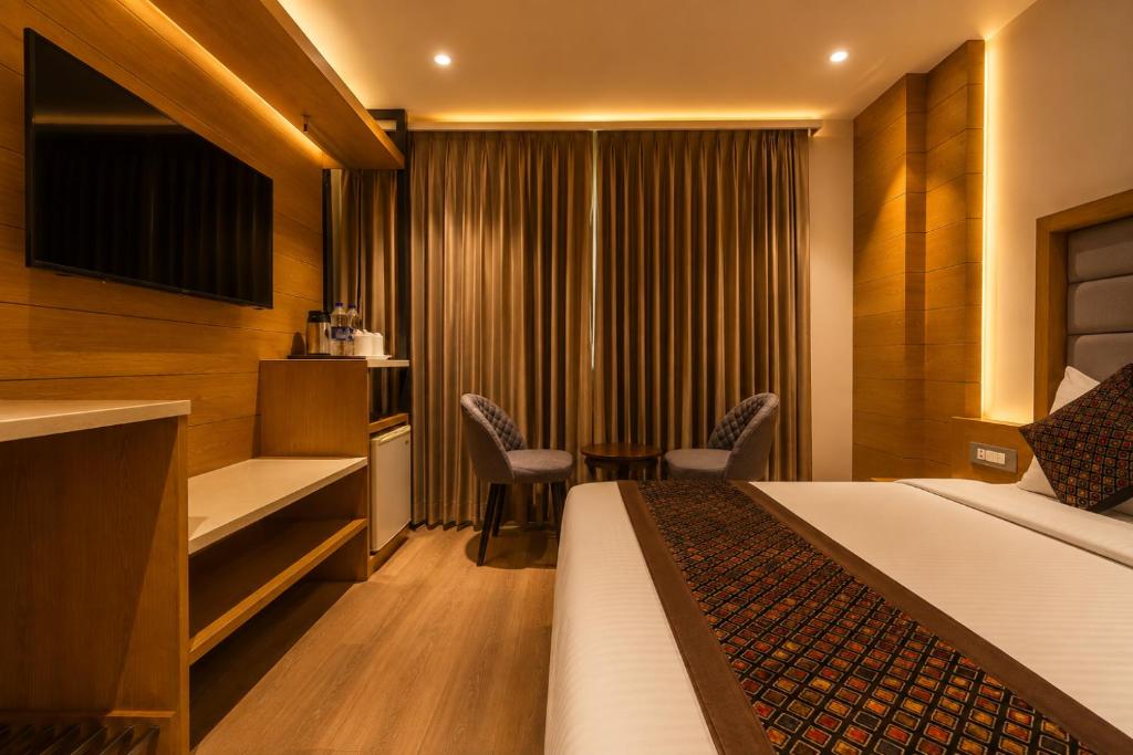 a hotel room with a bed and a table and chairs at Hotel Bricks, Karol Bagh, New Delhi in New Delhi