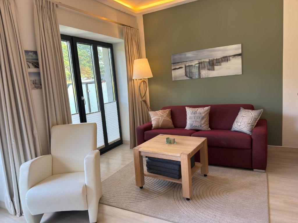 a living room with a couch and a chair and a table at Strand FeWo Rügen Baltic Sea in Binz