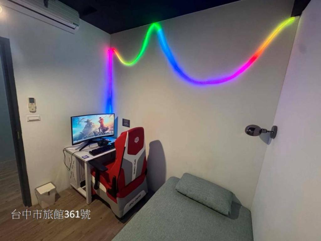 a room with a desk and a computer on a wall at 電競客棧宜舍館 in Taichung