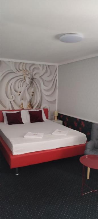 a bedroom with a large bed with a red headboard at Pensiunea Casa Copou in Iaşi