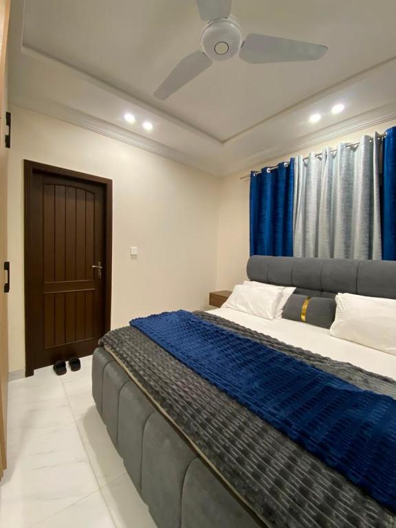 a bedroom with a large bed with a ceiling fan at City Haven Faisalabad in Faisalabad