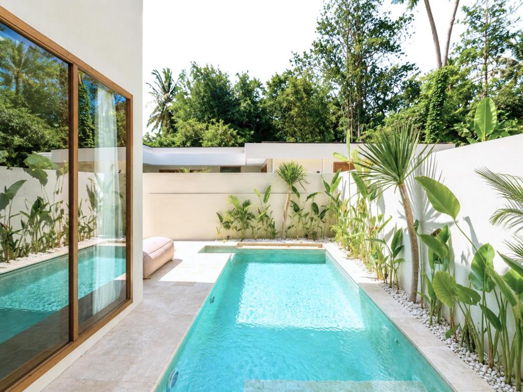 a swimming pool in the backyard of a house at Oasis Dune Villas Lombok in Kuta Lombok