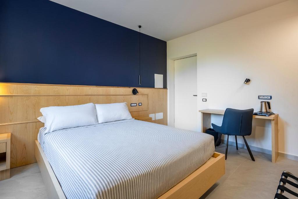 a bedroom with a bed and a desk and a chair at Istedda Boutique Hotel in Villasimius