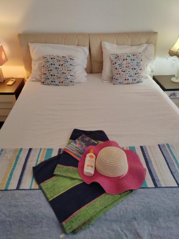 a bed with a hat and towels on it at Apartman Angela in Budva