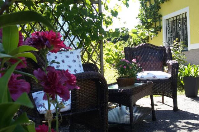 eine Terrasse mit 2 Stühlen und einem Tisch mit Blumen in der Unterkunft Haus Lerchenreith in Bad Aussee