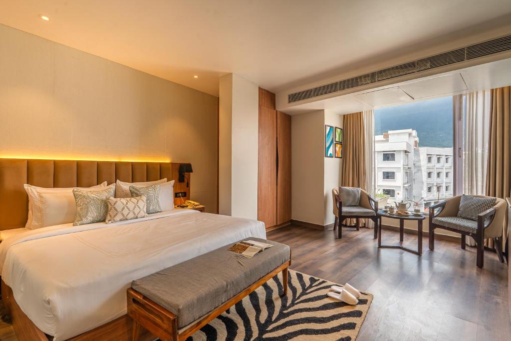 a hotel room with a bed and a table and chairs at Perfectstayz Premium Mahadev Regency in Katra