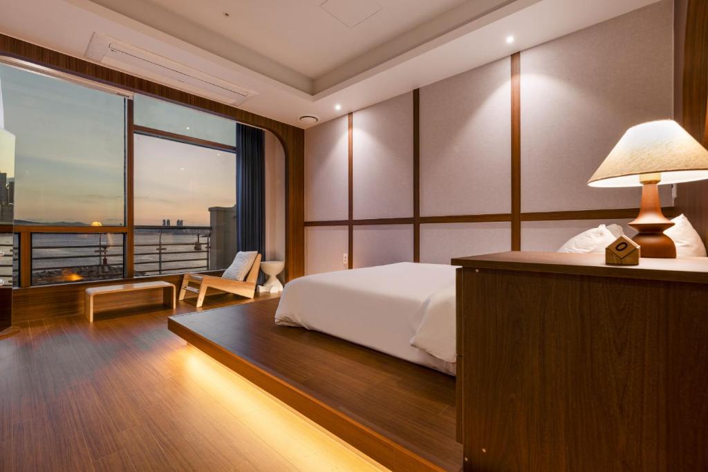 a bedroom with a bed and a large window at Marysol Stay in Busan