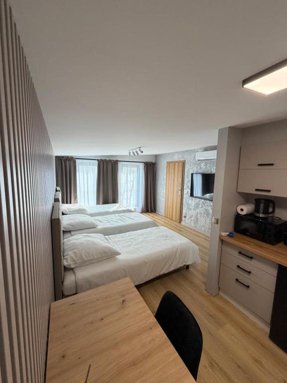 a hotel room with a large bed and a table at Sunrise Apartamenty in Chocicza
