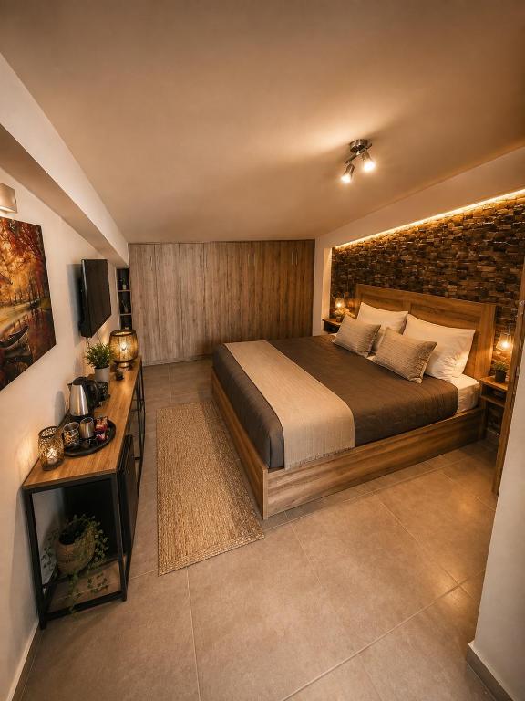a bedroom with a large bed and a brick wall at Airport Sea View - Studio - 15 mins from Athens Airport in Artemida