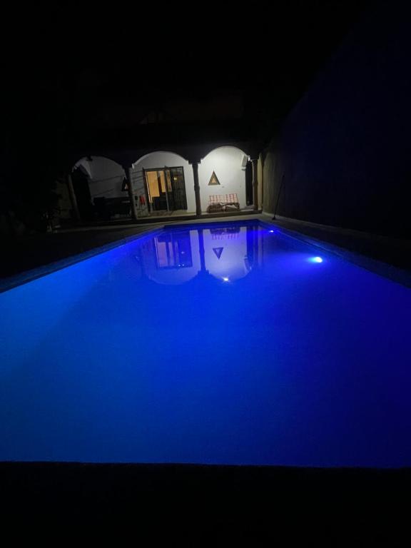 a swimming pool with blue lights in a dark room at Villa 4 in Saly Portudal