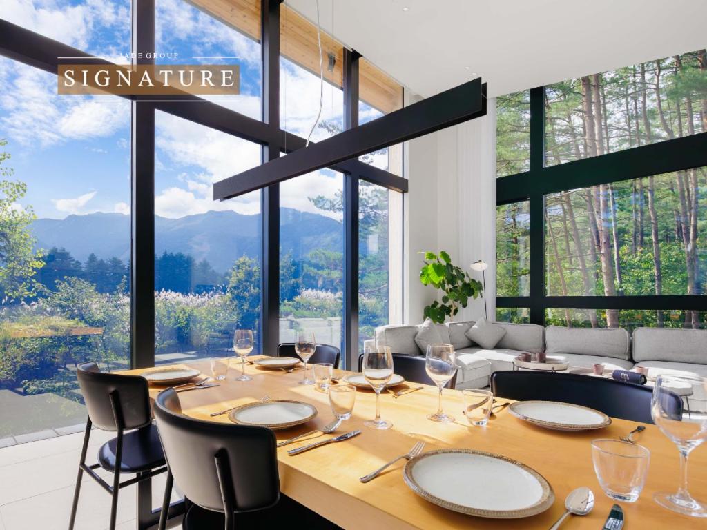 a dining room with a table with wine glasses at Hakuba Aura Chalet by Jade Villa in Hakuba