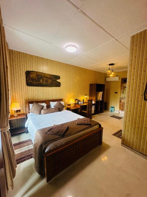a bedroom with a large bed and a desk at Liana Guest House Ella in Ella
