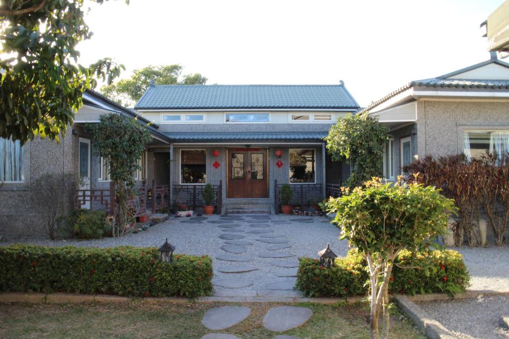 a house with a stone walkway leading to the front door at 池上福吉園素食民宿 臺東縣民宿073號 請勿透過阿勾達訂房 in Chishang