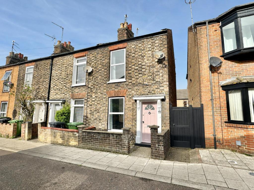 a brick house with a pink door on a street at Waterloo Street in King's Lynn