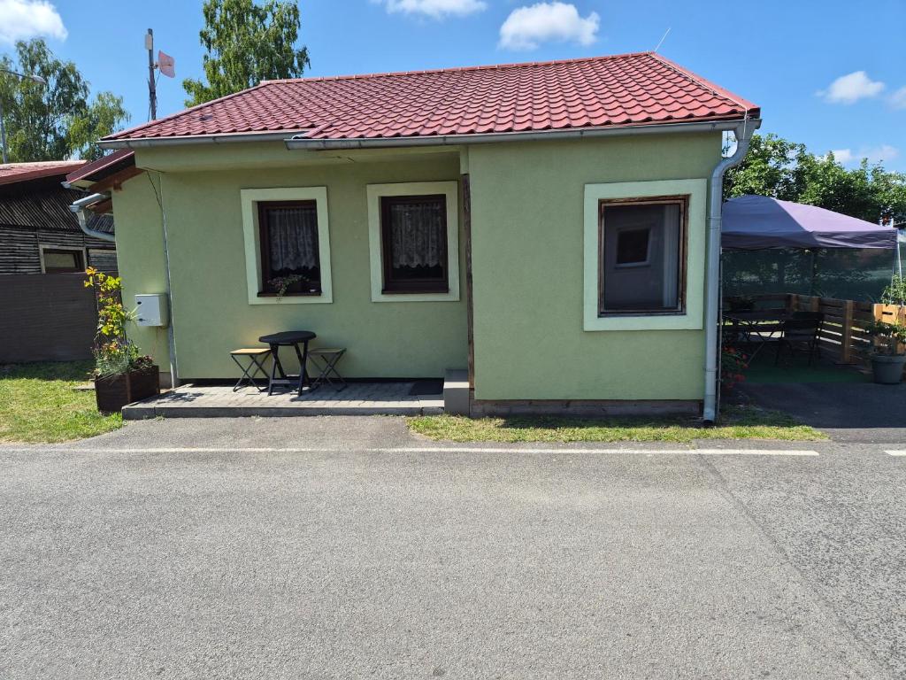 a small green house with a red roof at Apartmány Mácháč in Doksy