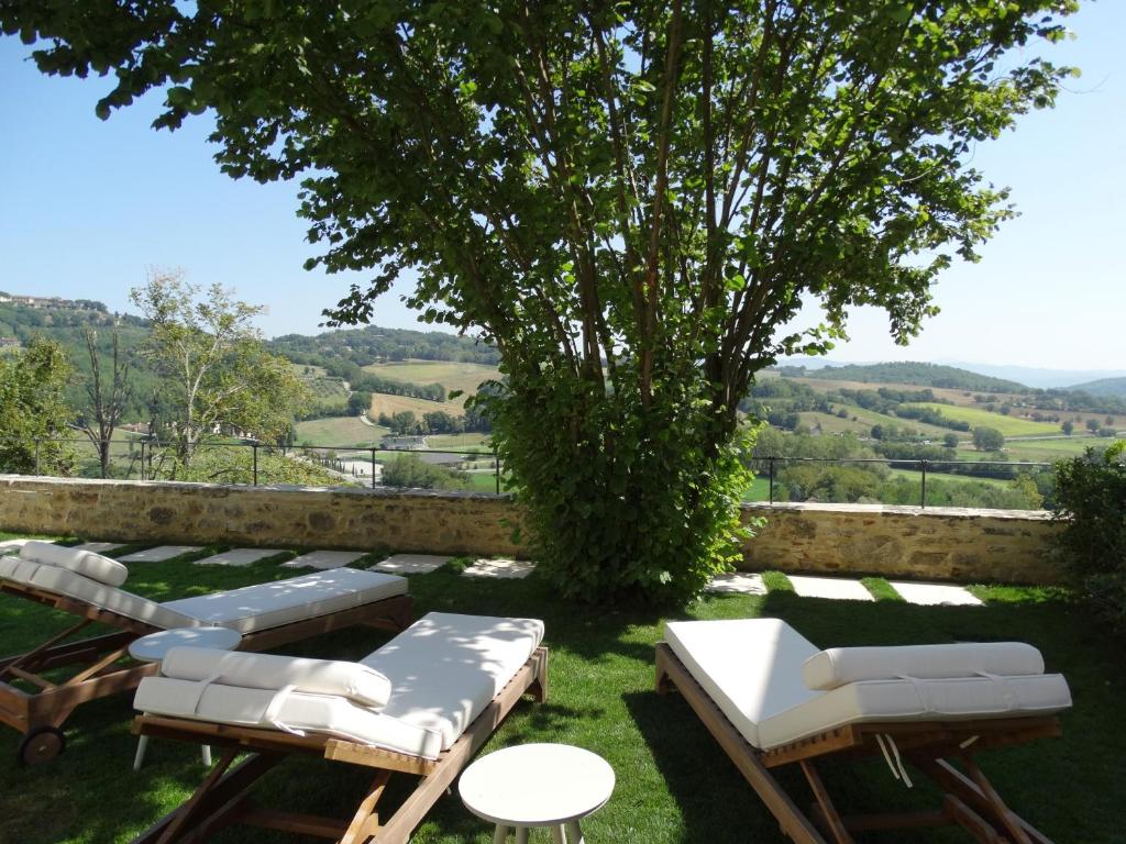 a garden with lounge chairs and a tree at A Family Tale - Una Storia Di Famiglia in Monterchi