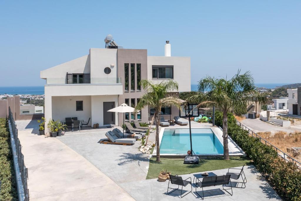 a villa with a swimming pool and the ocean at Aetheria Luxury Villa in Kalithies