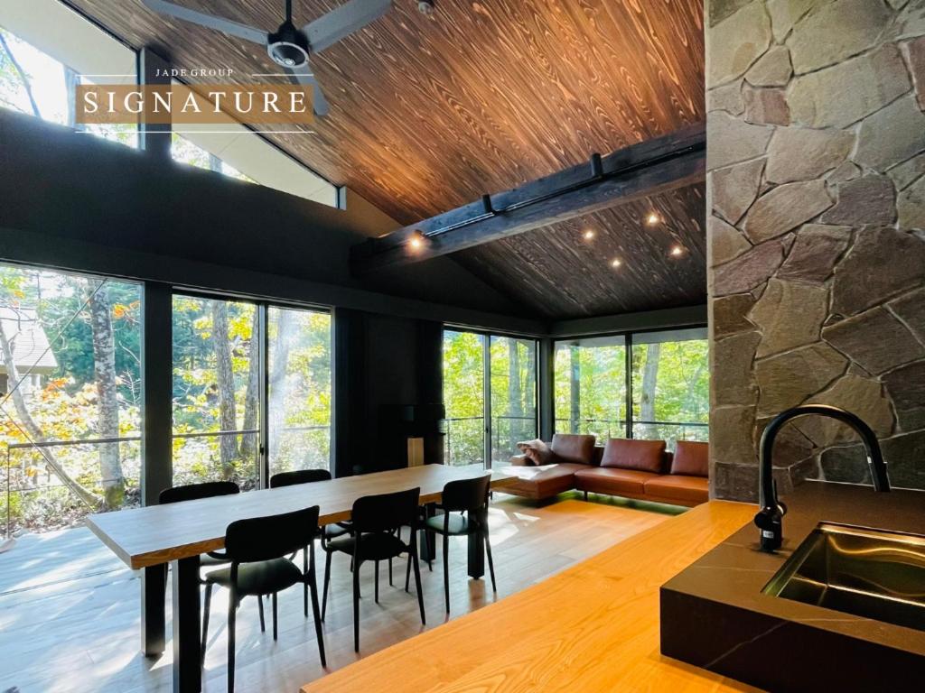 a kitchen and living room with a table and chairs at Hakuba Aurora Chalet by Jade Villa in Hakuba