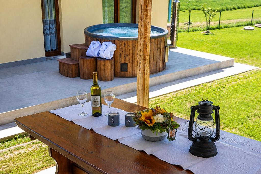 a table with a bottle of wine and two glasses at Kuća Trota - sauna, HOT TUB in Otočac