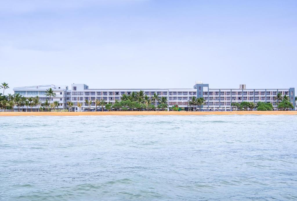 a large building on a beach with the water at Jie Jie Beach by Jetwing in Wadduwa