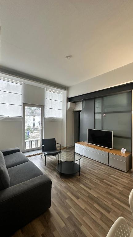 a living room with a couch and a flat screen tv at B@Home Apartments in Sanem