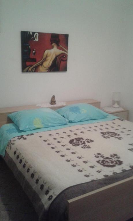 sypialnia z łóżkiem i obrazem na ścianie w obiekcie Apartmani Vilma w Bibinje