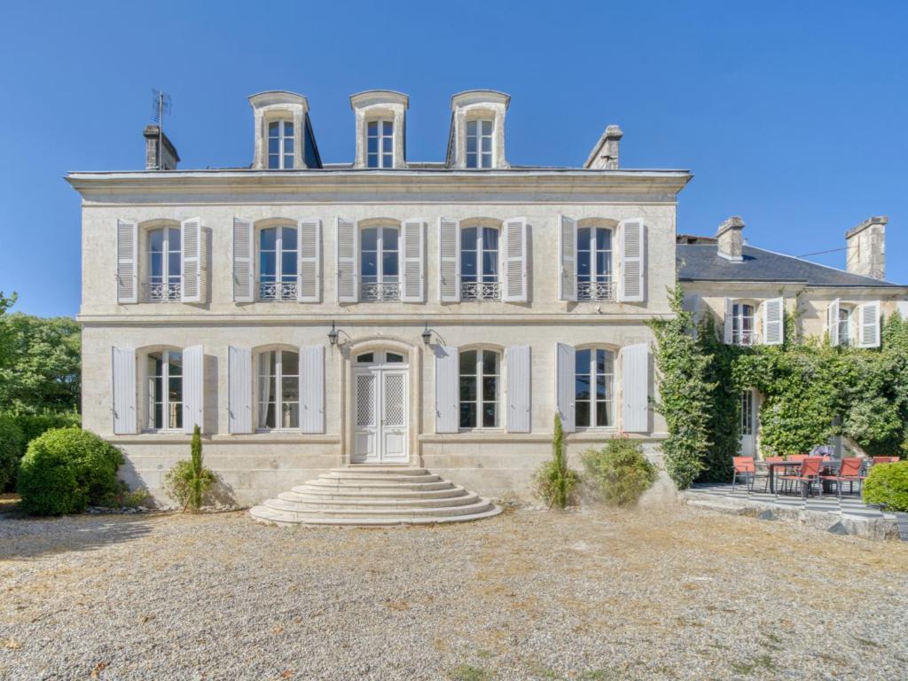 a large house with a staircase in front of it at Maison de maître, Piscine privée, 4 suites in Nersac