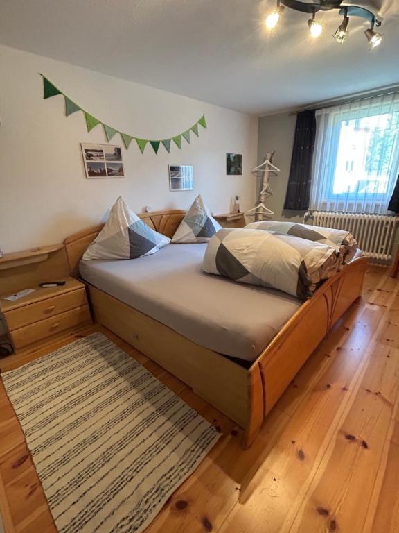 a bedroom with a bed with a green banner on the wall at Moosinest-Birkenzimmer in Schonach