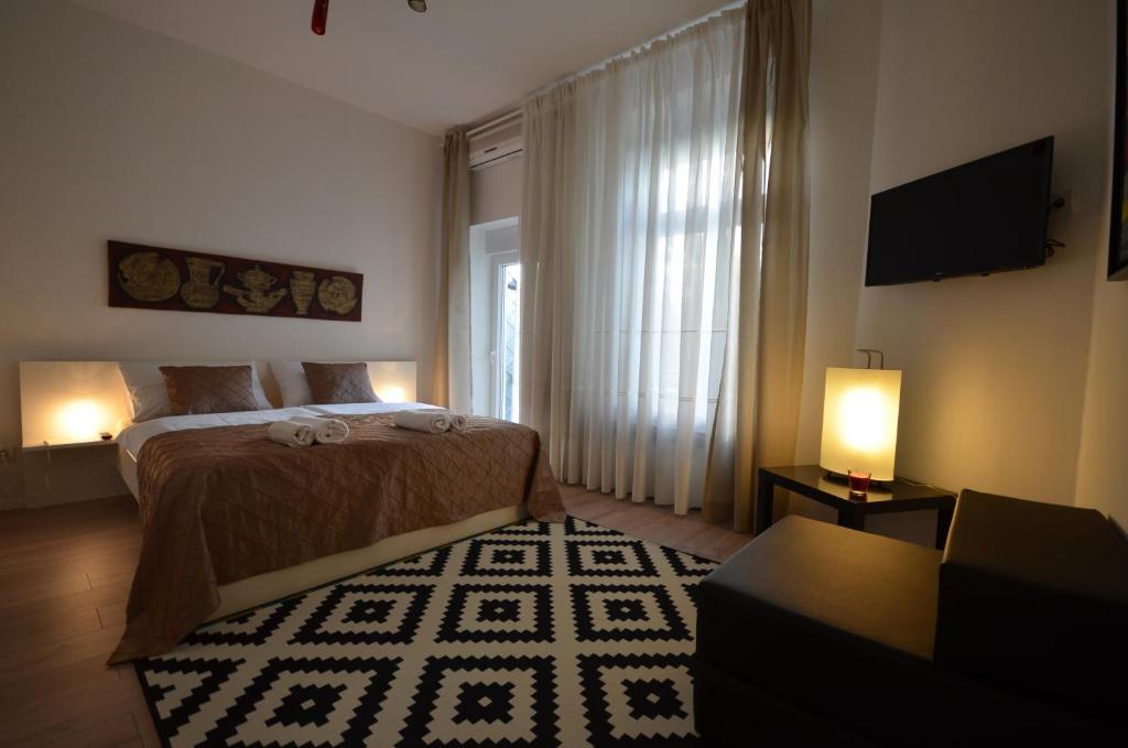 a bedroom with a bed and a window and a couch at Downtown Luxury Apartment in Zagreb