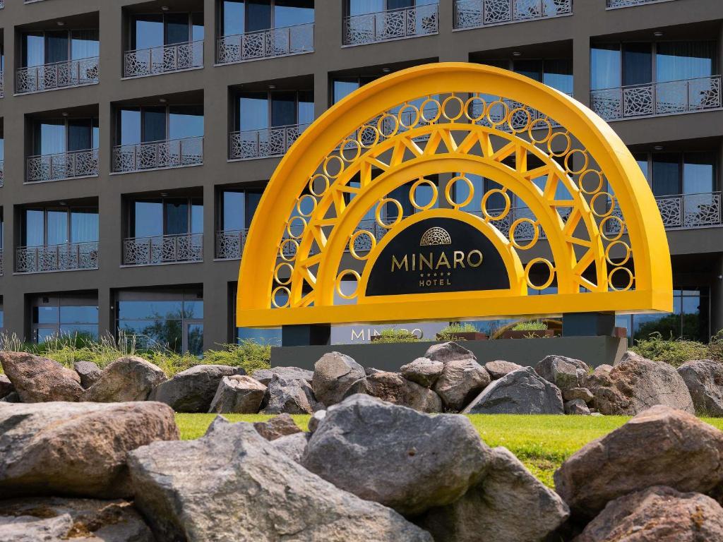 a sign in front of a building with rocks at Minaro Hotel Tokaj - MGallery Collection - Adults Only in Tokaj