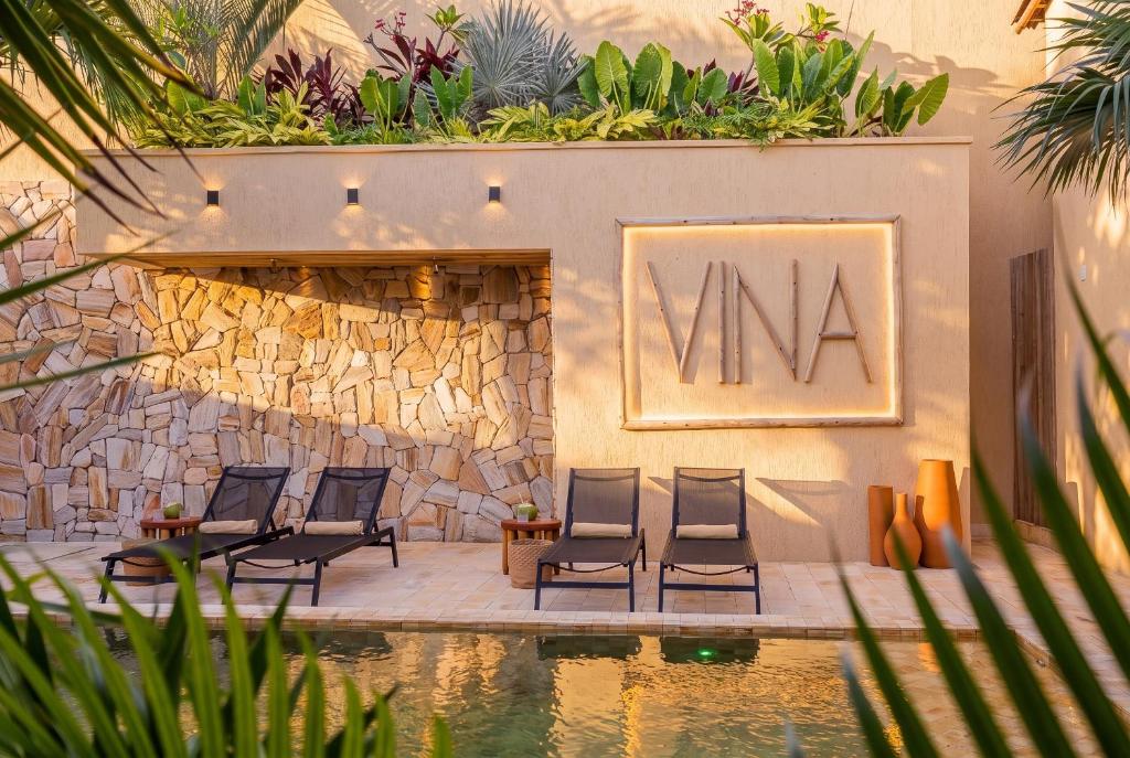 a group of chairs sitting next to a pool at Pousada Vina in Jericoacoara