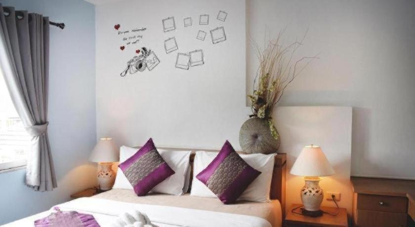 a bedroom with a bed with purple pillows and two lamps at EASTAN VIEW in Chiang Mai