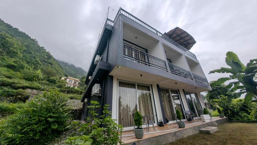 a house with a balcony on the side of it at Cliffs & Clouds in Bhīm Tāl